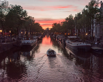 Boats in a canal in amsterdam while sunset 