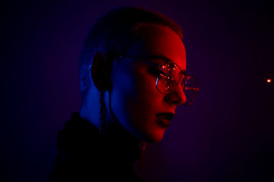 Portrait of woman wearing sunglasses against black background