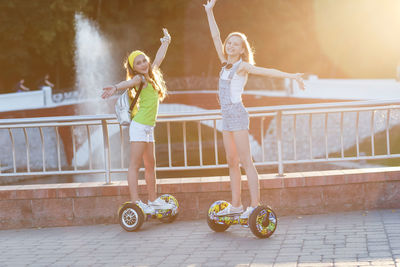 Full length portrait of female friends hovering on hoverboards at park