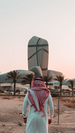 Rear view of woman standing against the sky