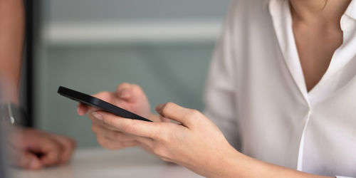 Midsection of woman using mobile phone