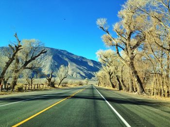 Empty road along snow covered landscape