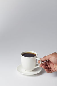 Person holding coffee cup against white background