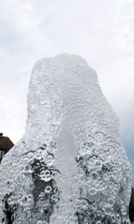 Close-up of snow on rock against sky