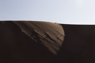 Sand dunes in desert against clear sky