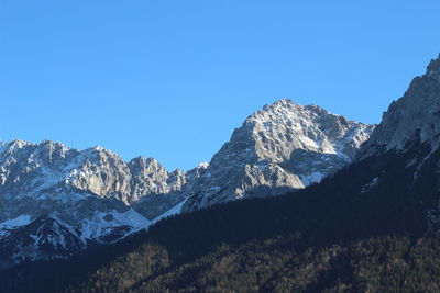 Scenic view of snowcapped mountains against clear blue sky