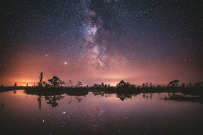 Scenic view of lake against sky at night