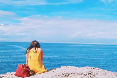 Rear view of young woman standing on beach