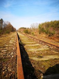 View of railroad tracks on field against sky