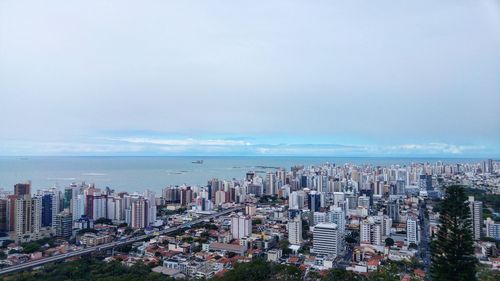 High angle view of buildings by sea against sky