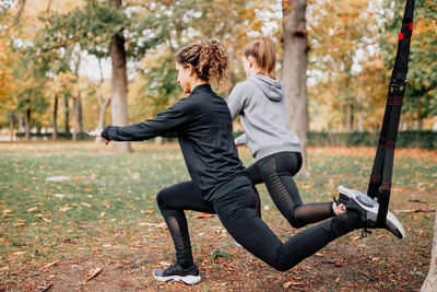 Rear view of women exercising in park