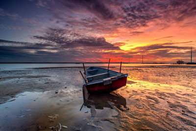 Boat on beach at sunset