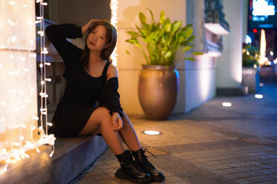 Portrait of young woman sitting on floor