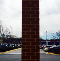 Cars on road against cloudy sky