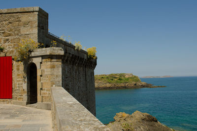 View of built structure by sea