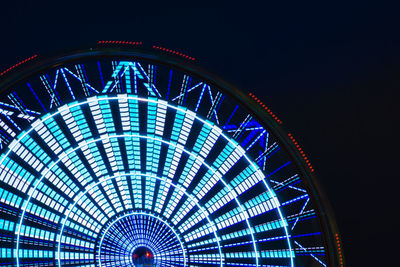 Low angle view of illuminated ferris wheel at night