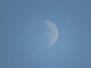 Low angle view of moon against blue sky