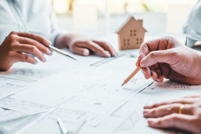 Midsection of architects working on blueprint