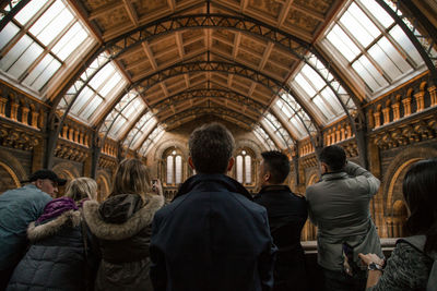 Rear view of people standing against ceiling