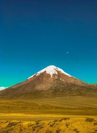 Scenic view of snowcapped mountains against clear blue sky