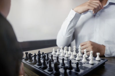 Midsection of man playing with chess against blurred background