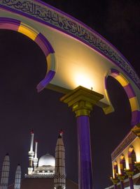 Low angle view of illuminated building against sky at night