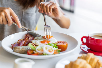 Midsection of woman eating food at restaurant