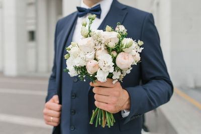 A man holds a wedding bouquet in his hands. the concept of valentine's day and love. wedding