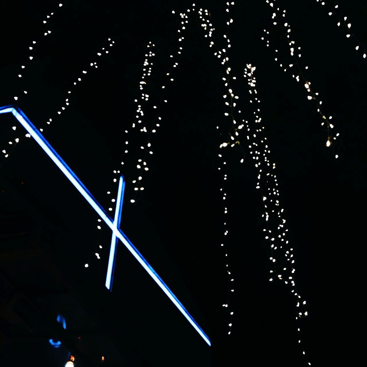 LOW ANGLE VIEW OF ILLUMINATED LIGHTING EQUIPMENT AT NIGHT