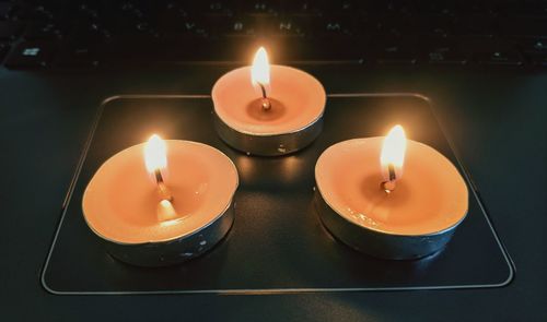 Close-up of lit candle on table