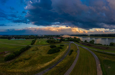 Panoramic view of road amidst field against sky during sunset