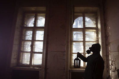 Man photographing through window in building