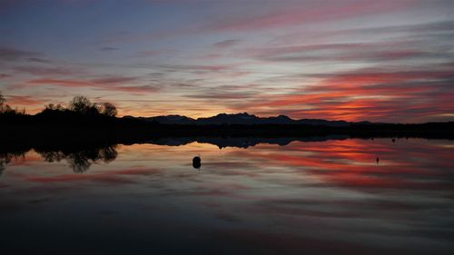 Scenic view of lake against orange sky