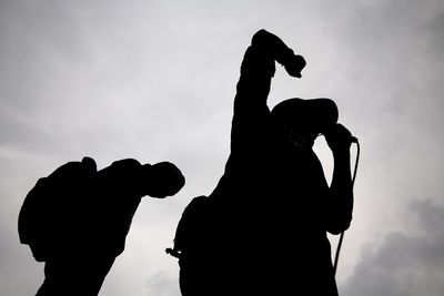 Low angle view of silhouette public speaker giving speech against sky