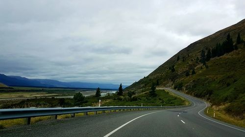 Empty road by mountain against sky