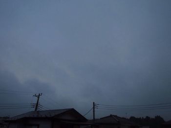 Low angle view of silhouette electricity pylon against sky