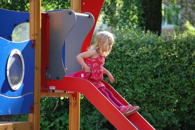 View of girl playing on slide at playground