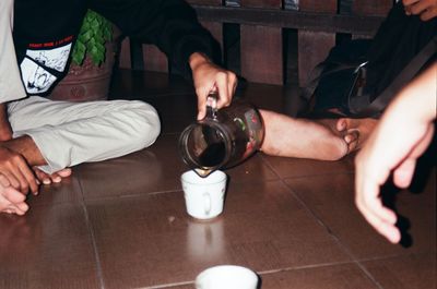 Low section of man sitting on table