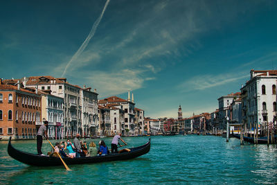 Boats in canal along buildings in city