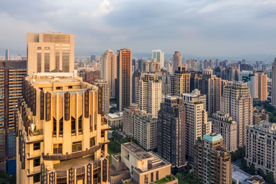 Aerial view of buildings in city against sky