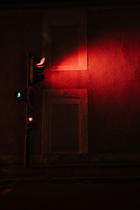 Red door with text on wall at night