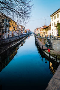 Canal amidst buildings in city against clear sky