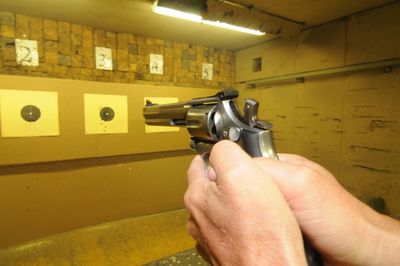 Target shooter at a shooting range, indoor sports with weapon