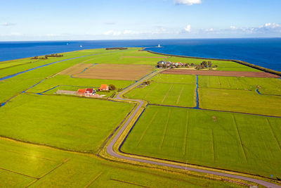 High angle view of agricultural field by sea against sky