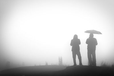 Silhouette people against clear sky