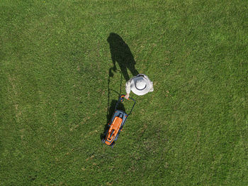 Woman with lawn mower standing in back yard