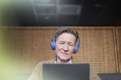 Senior man with headphones using tablet