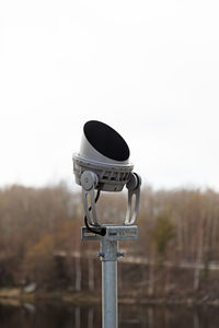 Close-up of electric lamp on field against clear sky