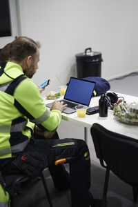 Man using laptop in canteen