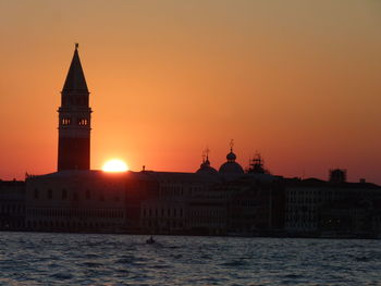 Church of san giorgio maggiore by lake against sky during sunset in city